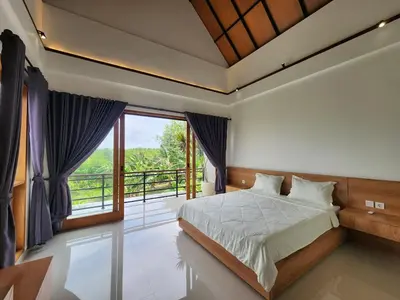 a bedroom with a bed and a large window at Best Villa in Jimbaran