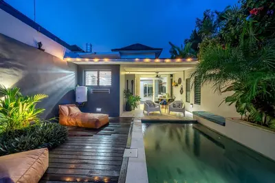 a backyard with a swimming pool and a house at Villa 111 - Romantic 1BR Villa in Batu Belig in Seminyak