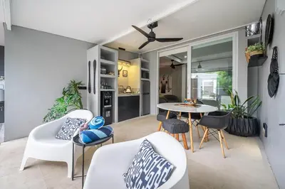 a living room with white chairs and a table at Villa 111 - Romantic 1BR Villa in Batu Belig in Seminyak