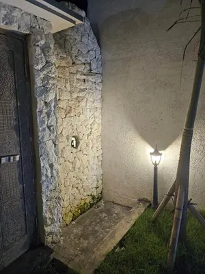 a light next to a stone wall with a door at Mediterranean Villa Sanur Beach in Sanur
