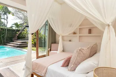 a bedroom with a bed and a swimming pool at Villa Anicca - Family-Friendly 4BR Villa Umalas With Private Pool And Rooftop Lounge in Canggu