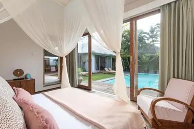 a bedroom with a bed and a view of a pool at Villa Anicca - Family-Friendly 4BR Villa Umalas With Private Pool And Rooftop Lounge in Canggu