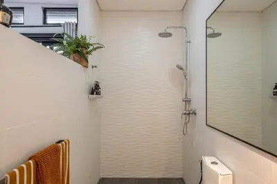 a bathroom with a shower with a toilet and a mirror at Villa 121 - Modern 1BR Villa Near Batu Belig Beach in Seminyak