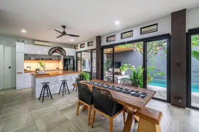 a kitchen and dining room with a table and chairs at Villa 121 - Modern 1BR Villa Near Batu Belig Beach in Seminyak