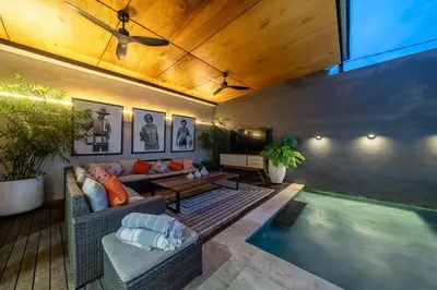 a living room with a couch and a pool at Villa 121 - Modern 1BR Villa Near Batu Belig Beach in Seminyak