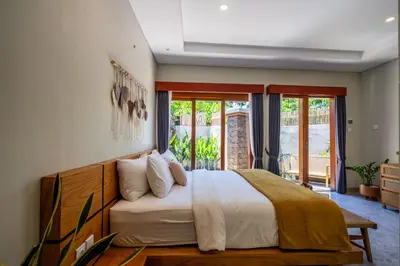 a bedroom with a large bed with white sheets at Semar Villa, a cozy studio Villa with a Private Pool, Bali in Legian