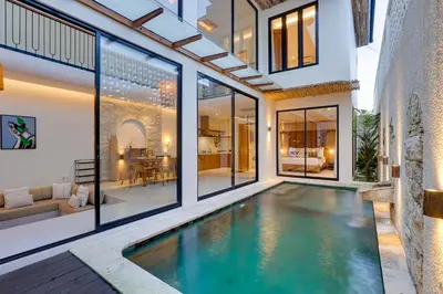 an indoor swimming pool in a house with large windows at Private 3BR Villa Sweetie with Pool Seminyak in Seminyak