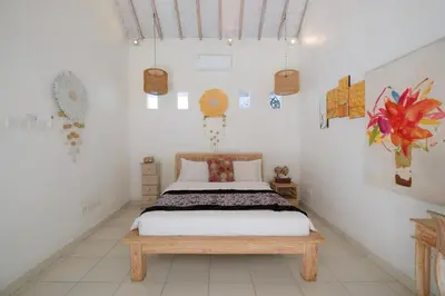 a bedroom with a bed and some paintings on the wall at Villa Beji Ayu Seminyak - 2 Bedroom Private Pool in Seminyak