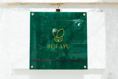 a green sign hanging on a wall with the word beel ay vuv at Villa Beji Ayu Seminyak - 2 Bedroom Private Pool in Seminyak