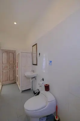 a white bathroom with a toilet and a sink at Villa Beji Ayu Seminyak - 2 Bedroom Private Pool in Seminyak