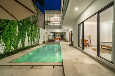 an indoor swimming pool with green ivy on the wall at Lindt - 3BR Villa with Private Pool and Ricefield View in Canggu