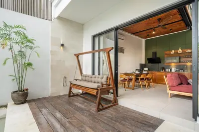 a living room with a swing and a dining room at Lindt - 3BR Villa with Private Pool and Ricefield View in Canggu