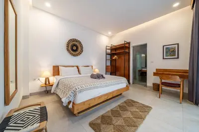 a bedroom with a bed and a desk and a piano at Lindt - 3BR Villa with Private Pool and Ricefield View in Canggu