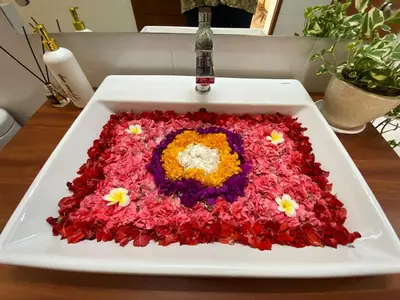 a white plate with a flower arrangement on a table at Arts Ebena Villa Two-Bedroom Private Pool Kuta in Seminyak