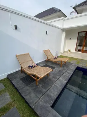 a patio with two chairs and a swimming pool at Arts Ebena Villa Two-Bedroom Private Pool Kuta in Seminyak
