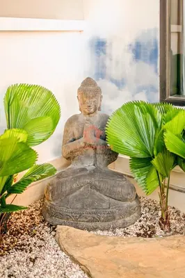 a statue of a buddha sitting in a garden at Luxury 3BR Umalas Villa Pool & Wi-Fi in Kerobokan