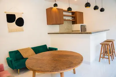 a living room with a table and a green couch at Satori Villa Umalas in Canggu