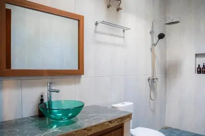 a bathroom with a glass bowl sink and a shower at Satori Villa Umalas in Canggu