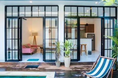 a house with glass doors and a living room at Satori Villa Umalas in Canggu