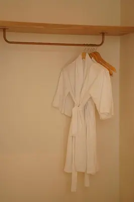 a white robe is hanging on a rack at 5 min to Finns Beach Club & Trendy Hotspot in Canggu