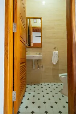 a bathroom with a sink and a mirror and a toilet at Villa Sunshyne in Seminyak