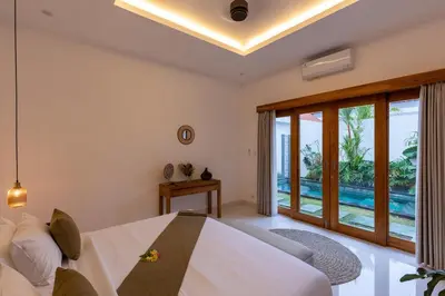 a bedroom with a bed and a large window at Villa Sunshyne in Seminyak