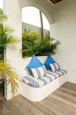 a bench with blue and white pillows on it at Tuluscoliving villa kuta 2, 4 Bedroom & 5 Bathroom in Ngurah Rai International Airport