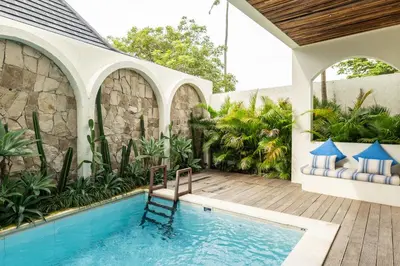 an outdoor swimming pool with a patio and a house at Tuluscoliving villa kuta 2, 4 Bedroom & 5 Bathroom in Ngurah Rai International Airport