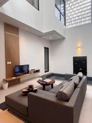 a living room with a large couch and a tv at Villa Jasmine in Seminyak