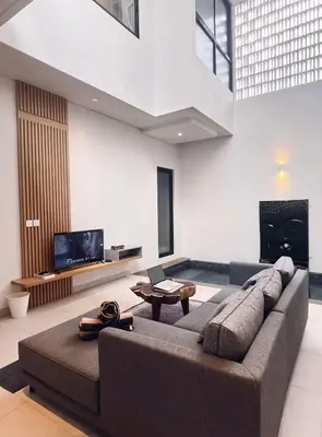 a living room with a large couch and a tv at Villa Jasmine in Seminyak
