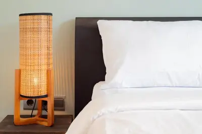 a bedroom with a bed with a lamp next to it at Villa Orchid Berawa in Canggu