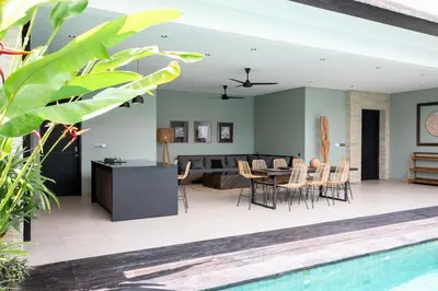 a living room and dining room with a table and chairs at Villa Orchid Berawa in Canggu