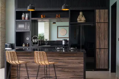 a kitchen with two bar stools and a counter at Villa Orchid Berawa in Canggu