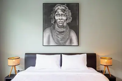 a black and white picture of a man above a bed at Villa Orchid Berawa in Canggu