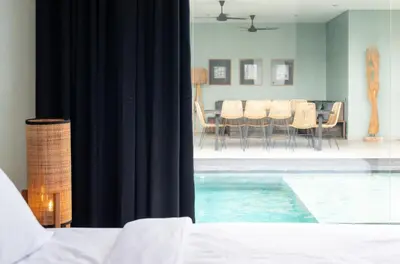 a room with a swimming pool and a dining room at Villa Orchid Berawa in Canggu
