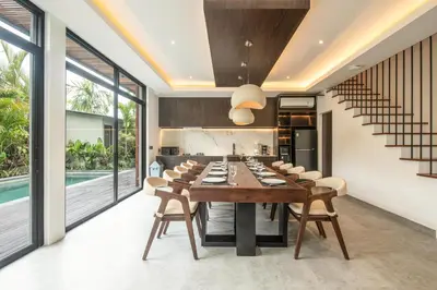 an open kitchen and dining room with a long table and chairs at Enchanting 5BR Canggu Villa Moments to Sea in Canggu
