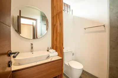 a bathroom with a sink and a toilet and a mirror at Coastal Chic 5BR Luxury Villa Canggu Beachside in Canggu