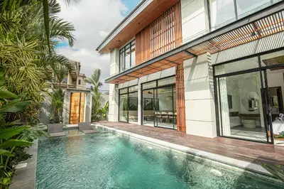 a swimming pool in front of a house at Coastal Chic 5BR Luxury Villa Canggu Beachside in Canggu