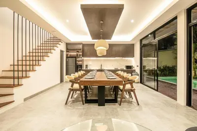 an open kitchen and dining room with a table and chairs at Coastal Chic 5BR Luxury Villa Canggu Beachside in Canggu