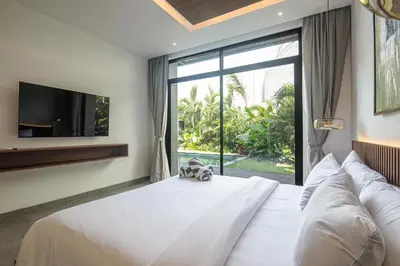 a bedroom with a large bed with a large window at Hidden Paradise 5BR Canggu Gem Near Waves in Canggu