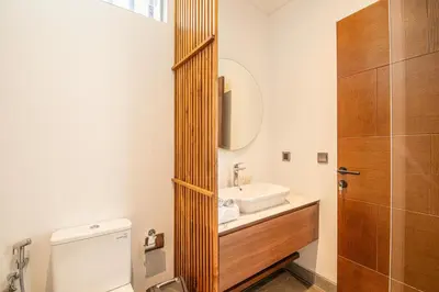 a bathroom with a sink and a toilet and a mirror at Hidden Paradise 5BR Canggu Gem Near Waves in Canggu
