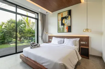 a bedroom with a large bed and a large window at Hidden Paradise 5BR Canggu Gem Near Waves in Canggu