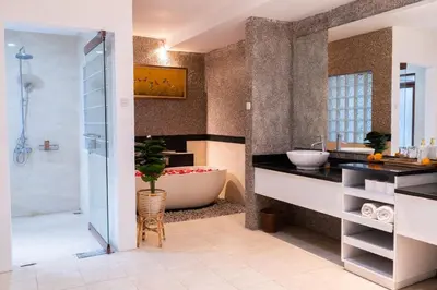a bathroom with a large tub and a sink at Karen's Tropical Villa in Seminyak