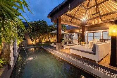 an outdoor living area with a pool and a villa at Karen's Tropical Villa in Seminyak