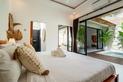 a bedroom with a large white bed with a large window at Cozy 2BR Villa Nara with Private Pool and Fitness Corner in Seminyak -Bali in Seminyak