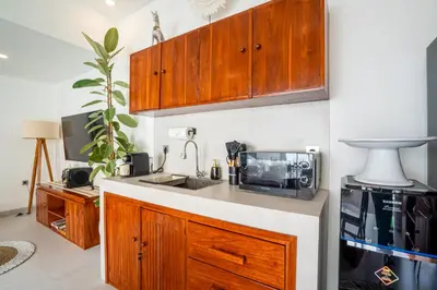 a kitchen with a sink and a microwave at Cozy 2BR Villa Nara with Private Pool and Fitness Corner in Seminyak -Bali in Seminyak