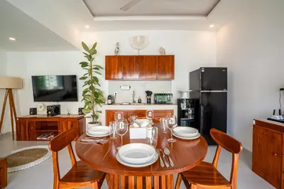 a dining room with a table and chairs and a kitchen at Cozy 2BR Villa Nara with Private Pool and Fitness Corner in Seminyak -Bali in Seminyak