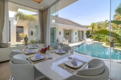 a dining room with a table and chairs and a pool at Villa Mattina, Umalas in Canggu