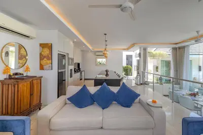 a living room with a white couch with blue pillows at Villa Mattina, Umalas in Canggu