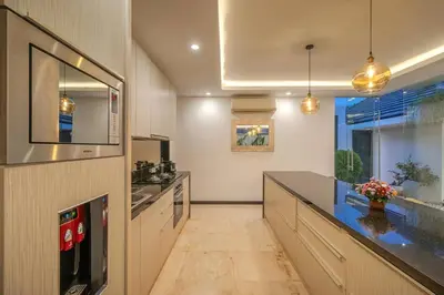 a kitchen with a counter and a sink and a refrigerator at Villa Mattina, Umalas in Canggu